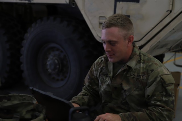 U.S. Army Spc. Joseph G. Muir Jr., an all wheels mechanic at V Corps, works on his laptop at Fort Knox, Kentucky, June 9, 2021. Muir was working on his computer to see what needed to be done.