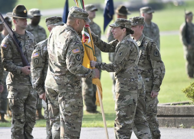 Brig. Gen. Niave Knell, U.S. Army Military Police School commandant, passes the 14th Military Police Brigade colors to Col. Kirk Whittenberger during a change-of-command ceremony July 14 on Gammon Field. 