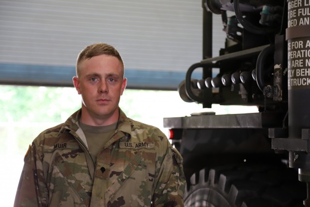 U.S. Army Spc. Joseph G. Muir Jr., a wheeled vehicle mechanic at V Corps, poses for a photo at the motorpool, at Fort Knox, Kentucky, June 9, 2021. Muir has earned V Corps Soldier of the Year through hard work and discipline. Muir competed for the Soldier of the Month and won, then competed in Soldier of the Year and won for V Corps but not overall.  (U.S. Army photo by Pvt. Gabriella Sullivan)