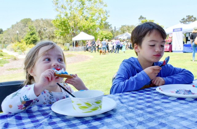 Eleanor Hartless, 3, and her brother Grant Hartless, 6, decorate and eat cookies during the “Party in the Park” at La Mesa Village, Monterey, Calif., July 9.