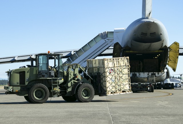 An Airman from 62nd Airlift Wing uses a forklift to load a container onto a C-5 Galaxy to deploy Army units for exercise Forager 21, at Joint Base Lewis-McChord, Wash., July 8, 2021. This exercise allows both the Army and Air Force stationed at JBLM to practice their ability to rapidly deploy forces to the Pacific.
