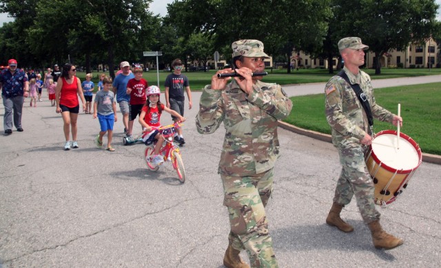 Playing a fife, Spc. Allison Wollam marches with drummer Staff Sgt. Adam Walton at the Independence Day celebration July 4, 2021, on Fort Sill, Oklahoma. The talented flutist has also played the bass drum and baritone saxophone.