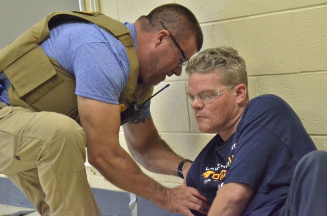 Sergeant Dave Keenom, Montgomery County Sheriff’s Office, left, practices applying a tourniquet to Jacob Hayes, a firefighter role-playing as a shooting victim, during Active Attack Integrated Response training, hosted July 12-16 at Jackson...