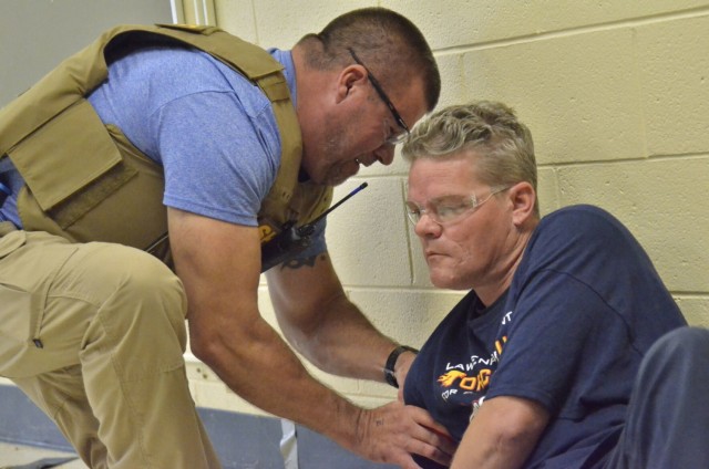 Sergeant Dave Keenom, Montgomery County Sheriff’s Office, left, practices applying a tourniquet to Jacob Hayes, a firefighter role-playing as a shooting victim, during Active Attack Integrated Response training, hosted July 12-16 at Jackson Elementary School.