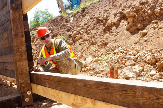 Sgt. Tyler Eckersley, a horizontal construction engineer with third platoon, Argonaut Troop, Regimental Engineer Squadron, 2nd Cavalry Regiment, screws a wood screw into the wooden frame of a 100-meter trench on Hohenfels Training Area, Hohenfels,...