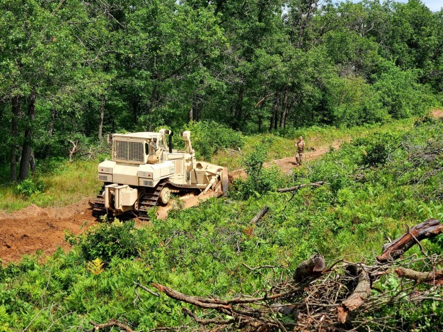 Spc. Seth Abbot with the Wisconsin National Guard's 950th Engineering Company (Route Clearance) operates a bulldozer at a training area July 12, 2021, at Fort McCoy, Wis. The work is part of a troop project coordinated by the Fort McCoy Directorate of Public Works to repurpose and rebuild a training area. The company, which is based in Superior, Wis., is completing the work as part of their annual training. The unit's Soldiers regularly train at Fort McCoy. (U.S. Army Photo by Scott T. Sturkol, Fort McCoy Public Affairs Office)