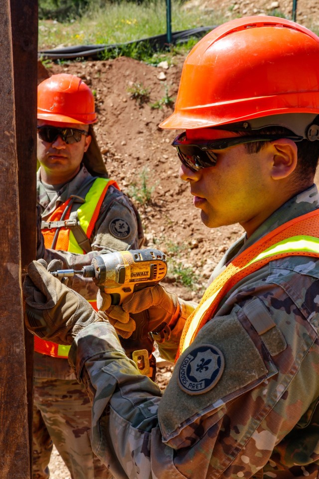 Spc. Kevin Beccarra, a horizontal construction engineer with third platoon, Argonaut Troop, Regimental Engineer Squadron, 2nd Cavalry Regiment, drills a wood screw into the frame of a 100-meter trench on Hohenfels Training Area, Hohenfels,...