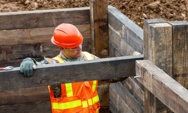 Sgt. James Cook, a horizontal construction engineer with third platoon, Argonaut Troop, Regimental Engineer Squadron, drills a screw into the frame of a 100-meter trench June 4, 2021 on Hohenfels Training Area, Hohenfels, Germany. The trench will...