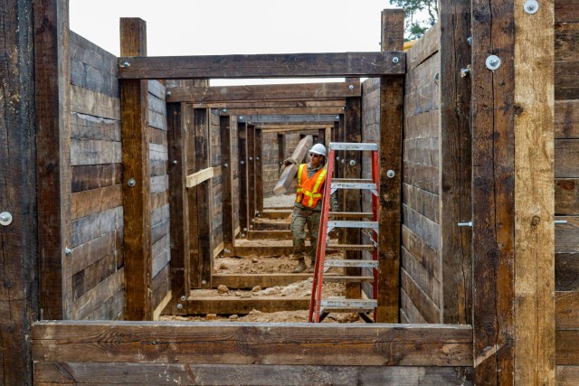 Spc. Matthew Lynch, a horizontal construction engineer with third platoon, Argonaut Troop, Regimental Engineer Squadron, 2nd Cavalry Regiment, carries a board during construction of a 100-meter trench on Hohenfels Training Area, Hohenfels,...