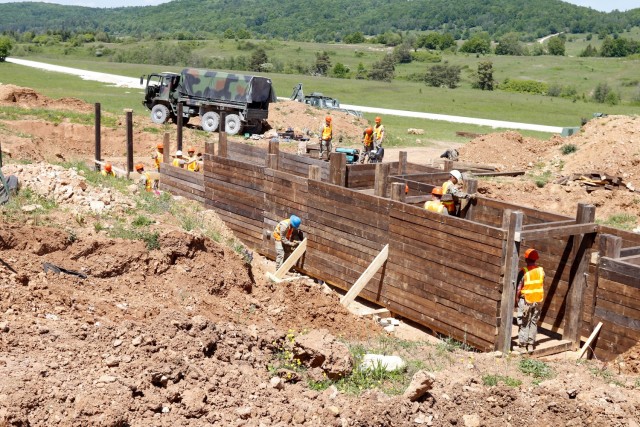 Engineers with the 2nd Cavalry Regiment's Regimental Engineer Squadron and the Joint Multinational Readiness Center's Troop Construction Program work on a 100-meter trench on Hohenfels Training Area, Hohenfels, Germany, June 3, 2021. The trench...