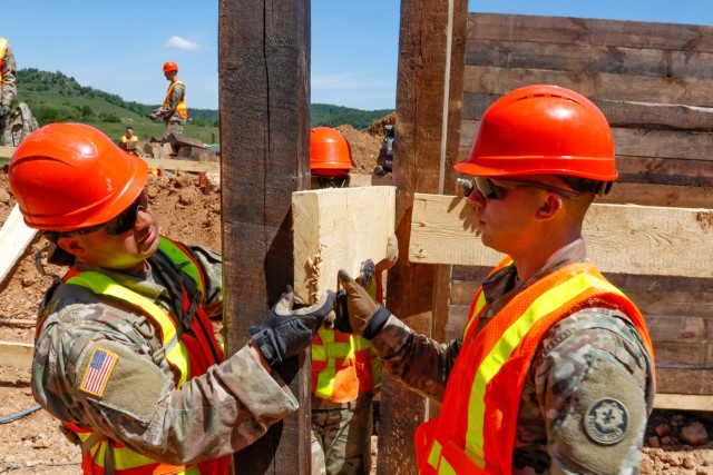 Sgt. Edgar Ortiz, left, a horizontal engineer with third platoon, Argonaut Troop, Regimental Engineering Squadron, 2nd Cavalry Regiment, and Spc. Garrett Easterling, also from third platoon, work on the wooden frame of a 100-meter trench on...