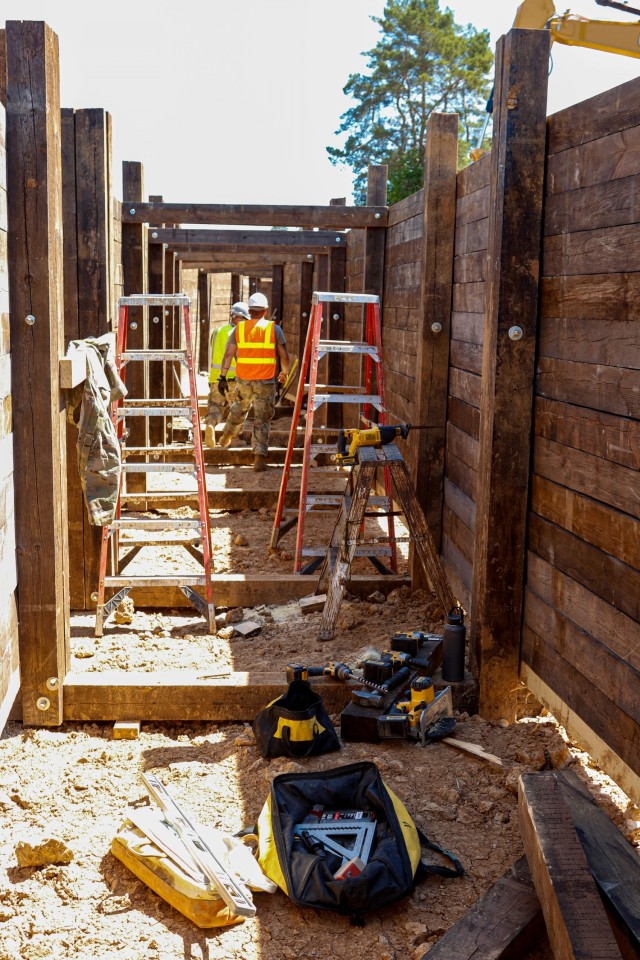 Sgt. Edgar Ortiz, left, a horizontal engineer with third platoon, Argonaut Troop, Regimental Engineering Squadron, 2nd Cavalry Regiment, and Spc. Garrett Easterling, also from third platoon, work on the wooden frame of a 100-meter trench on...