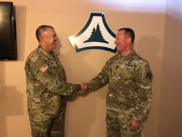 Fort McCoy Garrison Commander Col. Michael Poss shakes hands with Col. Ronald “R.J.” Hughes on June 24, 2021, at Fort McCoy, Wis. Poss was congratulating Hughes on his new command with the 181st Multi-Functional Training Command — a...