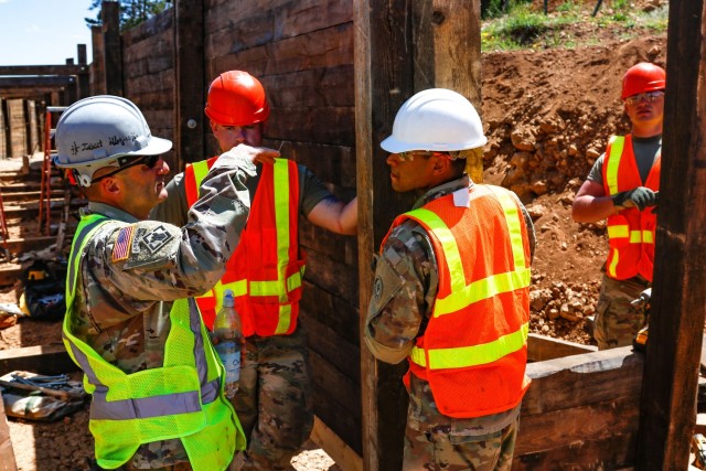 Chief Warrant Officer 2 Raymond Cowden, a construction engineering technician with the Joint Multinational Readiness Center’s Troop Construction Program, talks with engineer Soldiers from third platoon, Argonaut Company, Regimental Engineer...