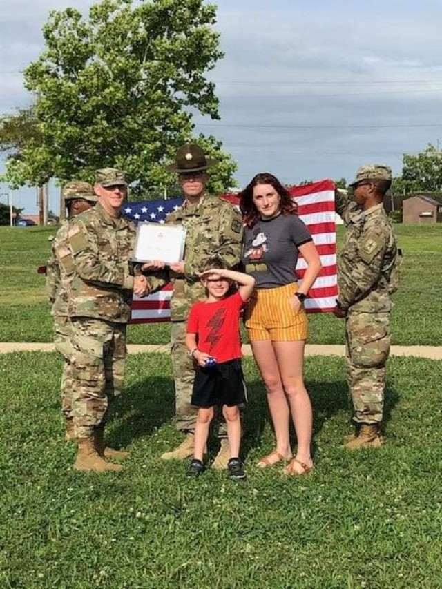 (Center) SFC Tyler Ray Price, during his promotion and reenlistment while serving as a drill sergeant at Fort Leonard Wood, Missouri, with wife Mackenzie and son Connor.