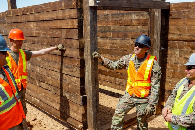 From left, Capt. Amauri Padilla, operations officer for the Joint Multinational Readiness Center's Troop Construction Program, 2nd Lt. Andrew Pitsenberger, third platoon leader, Argonaut Troop, Regimental Engineer Squadron, 2nd Cavalry Regiment,...