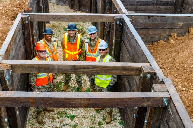 Members of the Joint Multinational Readiness Center’s Troop Construction Program stand inside a 100-meter trench they both designed and supervised the construction for on Hohenfels Training Area, Germany, June 4, 2021. The members of the team...