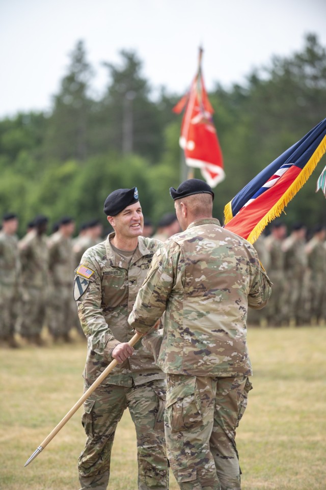 Maj. Gen. Richard Johnson, commanding general of Division West, 1st Army at Fort Hood, Texas, passes the 181st Multi-Functional Training Brigade flag to Col. Ronald “R.J.” Hughes on June 24, 2021, during a change of command ceremony for the...