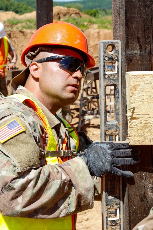 Sgt. Edgar Ortiz, left, a horizontal engineer with third platoon, Argonaut Troop, Regimental Engineering Squadron, 2d Cavalry Regiment, checks the level on the wooden frame of a 100-meter trench on Hohenfels Training Area, Hohenfels, Germany, June...