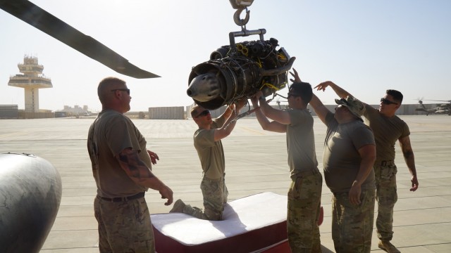 Aircraft mechanics take apart an old UH-60 Black Hawk helicopter engine at Al Asad Air Base, Iraq.