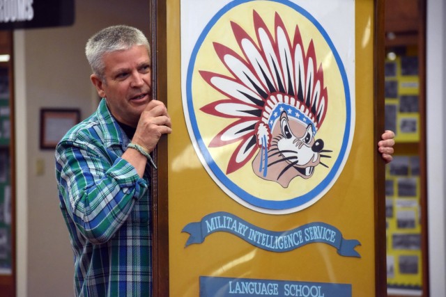 Joseph Ryan, deputy command historian, Defense Language Institute Foreign Language Center, shows children a picture of a former language school mascot during a visit from the Porter Youth Center to the Brig. Gen. Harry Dwight Chamberlin Library,...