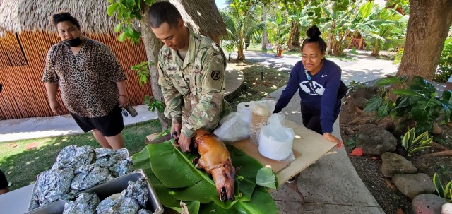 U.S. Army Sgt. Boyd Lauano, of the 9th Mission Support Command’s Task Force Oceania, prepares to serve a roasted pig to students from Brigham Young University-Hawaii at the Polynesian Cultural Center on June 6. The students and the Soldiers worked together to cook and prepare the meal as a good will gesture for the cultural exchange between the members of Task Force Oceania and the students. (U.S. Army photo by Sgt. Teresa Cantero)