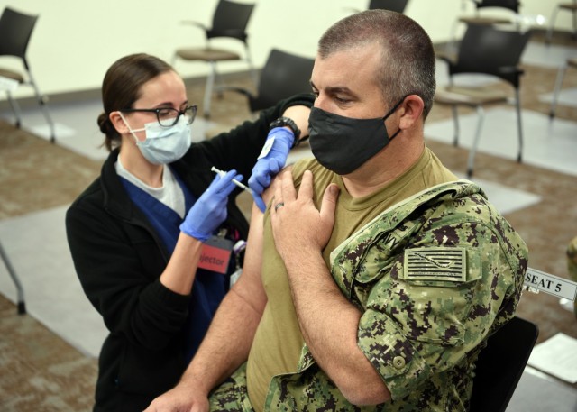 JOINT BASE SAN ANTONIO-LACKLAND AFB – (Feb. 1, 2021) Chief Quartermaster Harry Warner, of Alvin, Texas, an enlisted classifier/shipping clerk assigned to Navy Talent Acquisition Group (NTAG) San Antonio, receives the initial dose of the COVID-19 vaccine from Air Force 1st Lt. Sarah Caouette, a registered nurse, assigned to the Post Anesthesia Care Unit at Wilford Hall Ambulatory Surgical Center. “Our command handles applicants and future Sailors from all over the state of Texas,” said Warner.  “It only made sense to get the vaccine and lower my risk of catching it.  My team will be able to continue the mission of placing highly motivated Sailors into the Navy.” The Defense Department COVID-19 vaccine plan implements a standardized and coordinated strategy for prioritizing, distributing and administering any COVID-19 vaccine through a phased approach to vaccinate active component, reserve component, TRICARE Prime and TRICARE Select beneficiaries, and select DOD civilians and contract personnel authorized to receive immunizations from DOD. NTAG San Antonio’s area of responsibility includes two TAOCs which manage more than 34 Navy Recruiting Stations and Navy Officer Recruiting Stations spread throughout 144,000 square miles of Central and South Texas territory. (U.S. Navy photo by Burrell Parmer, NTAG San Antonio Public Affairs/Released)