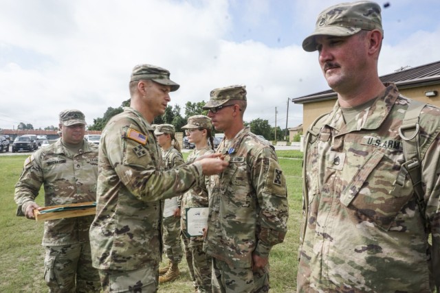 Capt. Anthony J. Cunningham, 846th Executive Officer and lead training officer, is awarded the Army Achievement Medal by Command Sgt. Major. Eric B. Olsen, senior enlisted advisor, 120th Infantry Brigade, for successfully organizing and completing a convoy live fire exercise at Clabber Creek gunnery range, July 14, 2021, Fort Hood, Texas. (U.S. Army Reserve Photo Staff Sgt. Erick Yates)