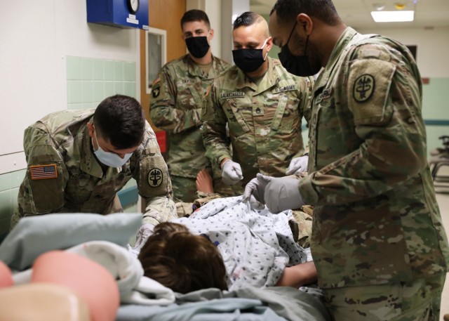 Soldiers from Regional Health Command-Atlantic and U.S. Army Medical Research and Development Command stabilize a notional patient during the assessment for the Delayed Evacuation Casualty Management (DECM) training held at Kimbrough Ambulatory Care Center July 16, 2021. From left to right: Sgt. Richard Gonzales, Kimbrough Ambulatory Care Center, Staff Sgt. Jeffrey Carter, U.S. Army Medical Research and Development Command, Staff Sgt. Edwin Galarzaseda, Fillmore Army Health Clinic, Staff Sgt. Edd Laurent, Walter Reed National Military Medical Center, completed the five-day course and learned critical care concepts preparing them to stabilize and sustain a casualty in an extended-care scenario before casualty evacuation. (U.S. Army photo by Michelle Gonzalez)