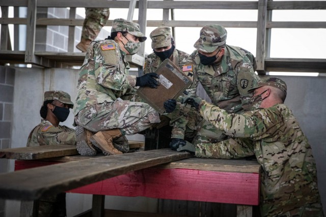 Soldiers with the Army Sustainment Command-Army Reserve Element read directions in preparation for crossing from one platform to another during a leadership reaction course that was part of Contracting Operational Readiness Exercise-21 at Camp Bullis, Texas. The unit regularly deploys Soldiers to augment worldwide missions that support Army Sustainment Command requirements. 