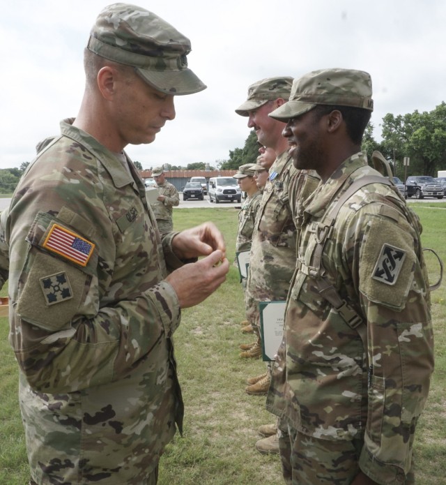 Staff Sgt. Brandon N. Moreno, squad leader and senior gunner, assigned to the 846th Transportation Company, is awarded the Army Achievement Medal by Command Sgt. Major. Eric B. Olsen, senior enlisted advisor, 120th Infantry Brigade, for successfully organizing and completing a convoy live fire exercise at Clabber Creek gunnery range, July 14, 2021, Fort Hood, Texas. (U.S. Army Reserve Photo Staff Sgt. Erick Yates)
