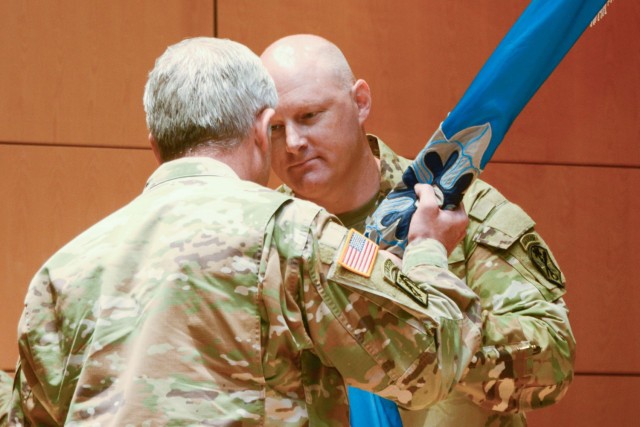 Maj. Gen. Gary W. Johnston, U.S. Army Intelligence and Security Command (INSCOM) commanding general, hands incoming commander of the National Ground Intelligence Center, Col. Christopher C. Rankin, the Center’s colors during the NGIC Change of Command Ceremony, July 13.