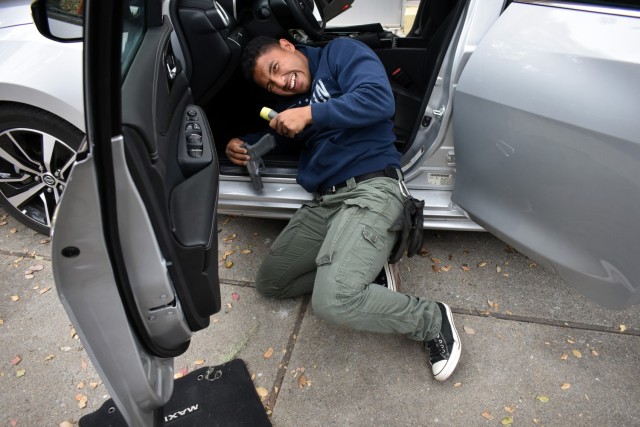 Officer Nery Cruz, a Presidio of Monterey security guard, smiles as he finds hidden contraband during vehicle interdiction training at the Stilwell Community Center, Ord Military Community, July 13.