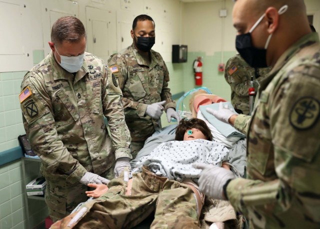 From left to right: Sgt. 1st Class Garrett Rogers, Fort Belvoir Community Hospital, Staff Sgt. Edd Laurent, Walter Reed National Military Medical Center, Staff Sgt. Edwin Galarzaseda, Fillmore Army Health Clinic, stabilize a notional patient during the assessment for the Delayed Evacuation Casualty Management (DECM) training held at Kimbrough Ambulatory Care Center July 16, 2021. Five Soldiers from Regional Health Command-Atlantic and the U.S. Army Medical Research and Development Command completed the five-day course and learned critical care concepts preparing them to stabilize and sustain a casualty in an extended-care scenario before casualty evacuation. (U.S. Army photo by Michelle Gonzalez)