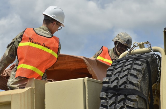 Privates First Class Dallen Galvez, left, and Victor Rowell, assigned to 326th Brigade Engineer Battalion, 1st Brigade Combat Team, 101st Airborne Division (Air Assault), secure a vehicle filled with debris for a trip to the landfill July 19...