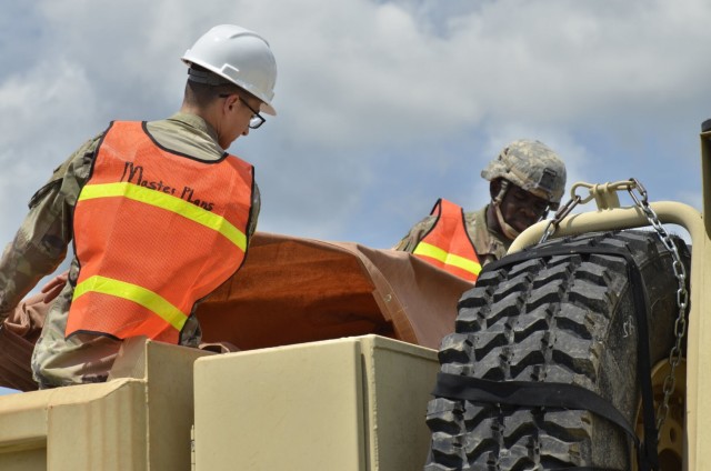 Privates First Class Dallen Galvez, left, and Victor Rowell, assigned to 326th Brigade Engineer Battalion, 1st Brigade Combat Team, 101st Airborne Division (Air Assault), secure a vehicle filled with debris for a trip to the landfill July 19 during the demolition of Building 873.