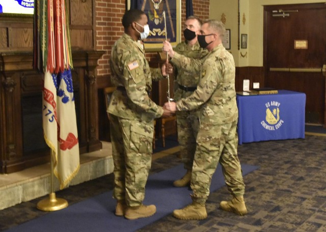 Incoming U.S. Army Chemical, Biological, Radiological and Nuclear School Regimental Chief Warrant Officer 3 Humphrey Hills (left) accepts a sword from Col. Sean Crockett, USACBRNS commandant, as outgoing Regimental Chief Warrant Officer 3 Robert...