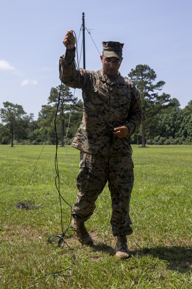 U.S. Marine Corps Cpl. Arnoldo Garcia, lays out 16-gauge copper wire as part of the HF Competition. 