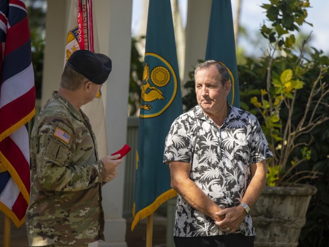 Army Sustainment Command commanding general, Maj. Gen. Chris Mohan, presents 402nd Army Field Support Brigade deputy to the commander, Joe Schulz, with the Ordinance Order of Samuel Sharpe.