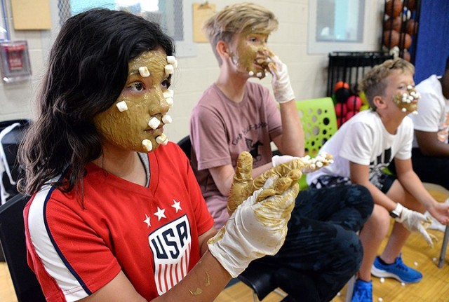 With their faces slathered in sunflower butter and plastered with thrown marshmallows, 12-year-olds Maraya Miller, Cadee Mensing and Aidan Nuce pause, and nibble, as the marshmallows are counted to see which team had the most stick during Teen...