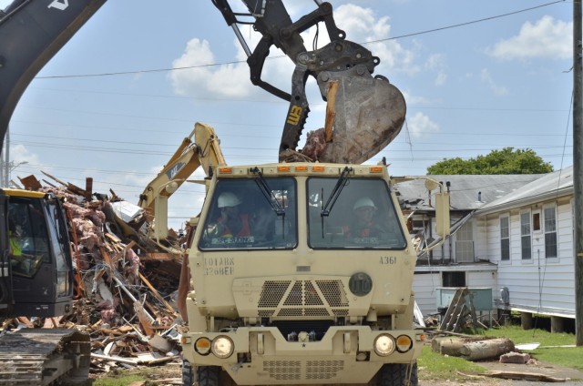 Corporal Abraham Ruiz, left, and Spc. Vyshaun Robinson, both assigned to 326th Brigade Engineer Battalion, 1st Brigade Combat Team, 101st Airborne Division (Air Assault), collect a load of debris July 19 from Building 873 during a demolition project. The debris will go to the landfill.