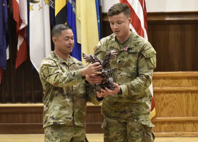 CPS.  Kaelan Pugh (right), a health care specialist with 5th Ranger Training Battalion, Fort Benning, Ga., This week won the Junior Enlisted category of the Best Warrior Training and Command Competition this week. US Army doctrine.  Combined Arms Center Command Sgt.  Major Steve Helton presented a Trophy and Meritorious Service Medal July 23 at the Lincoln Hall Auditorium on behalf of General Paul Funk, TRADOC Commanding General, and TRADOC Command Sgt.  Major Daniel Hendrex.