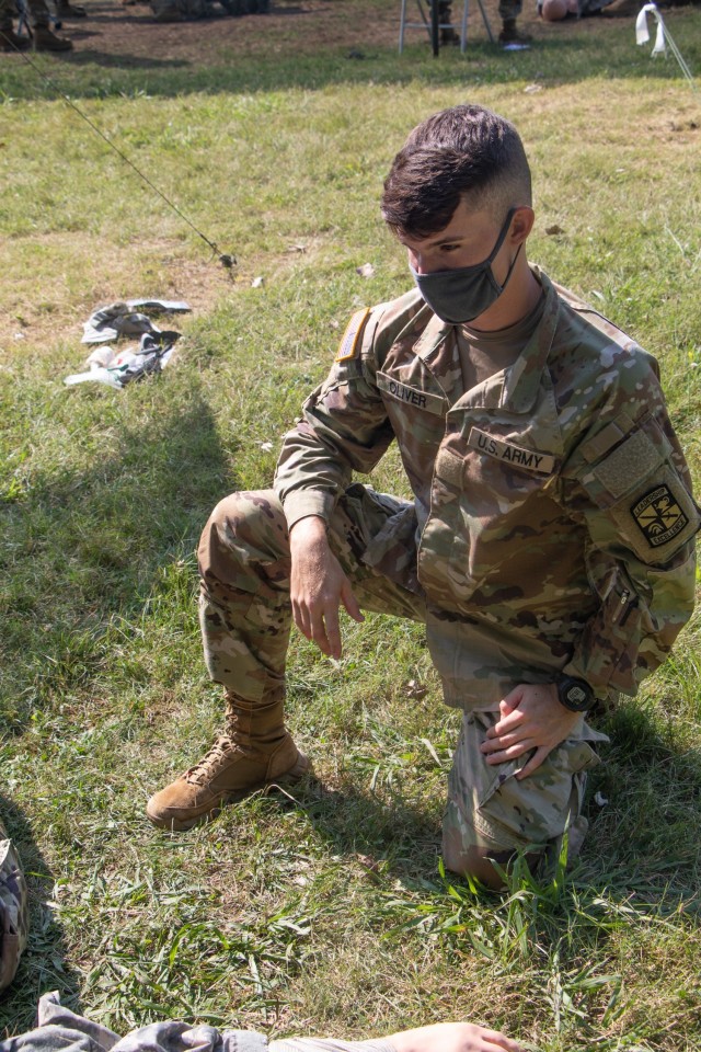 Cadet Randy Oliver, from University of Puerto Rico-Río Piedras Campus, watches his battle buddy complete his tactical combat care test at Warrior Skills at Advanced Camp at Fort Knox, Ky on July 7, 2021. | Photo by Marissa Wells, CST Public Affairs Office.