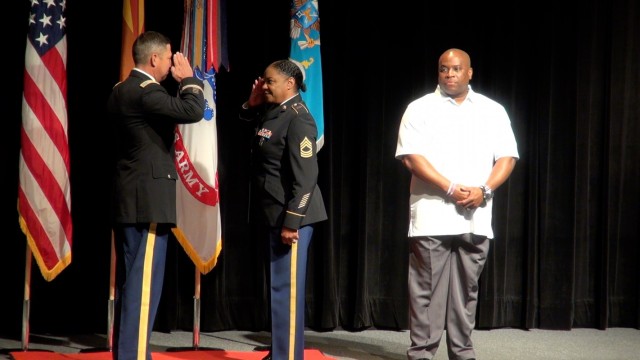 Col. Loren Traugutt, Commander, 111th Military Intelligence Brigade,  exchanges salutes with Master Sgt. Melinda Bridgeforth at a ceremony on Fort Huachuca, Ariz. 