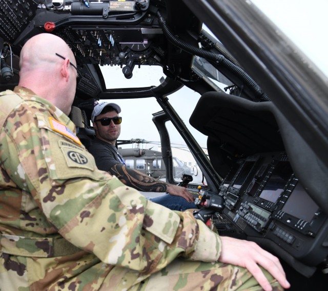 Decorated combat veteran and motivational speaker J.P. Lane sits in the cockpit of a UH-60 Black Hawk helicopter at Lowe Army Heliport with Chief Warrant Officer 3 John Cornelius, an aviator from the U.S. Army Aviation Center of Excellence's...