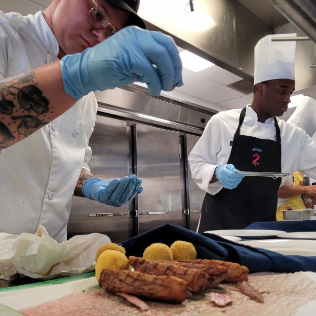 Spc. Jonathan Arendale, a culinary specialist with 3rd Squadron, 71st Cavalry Regiment, 1st Brigade Combat Team, makes sure his duck is perfectly seasoned before plating. The Fort Drum Student Chef Team has been training and practicing their menu since May in preparation for the 2021 American Culinary Federation (ACF) National Competition in Orlando, Florida, Aug. 2-5. (Photo by Mike Strasser, Fort Drum Garrison Public Affairs)