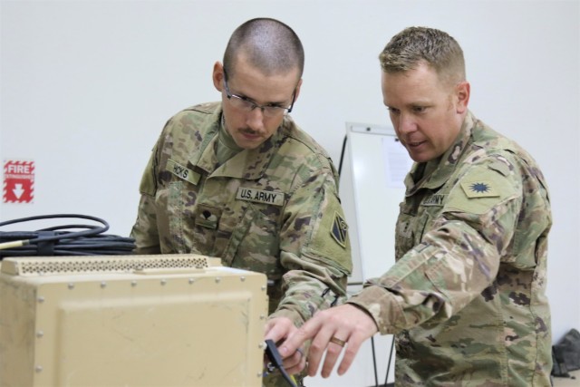 Chief Warrant Officer 2 Anthony Meneely, right, an Electronic Warfare Technician with Task Force Phoenix, instructs Spc. Curtis Hicks, from the Tennessee National Guard, 1-181st Field Artillery Battalion, on the operation of a Counter Radio-Controlled Improvised Explosive Device Warfare (CREW) system at Camp Buehring, Kuwait.