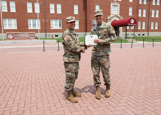 Lt. Col. Richard Gorini, staff judge advocate, 1st Theater Sustainment Command, presents an Army Commendation to Capt. Thomas Sandbrink, contract and fiscal law attorney, 1st TSC, July 21 at Fort Knox, Kentucky.