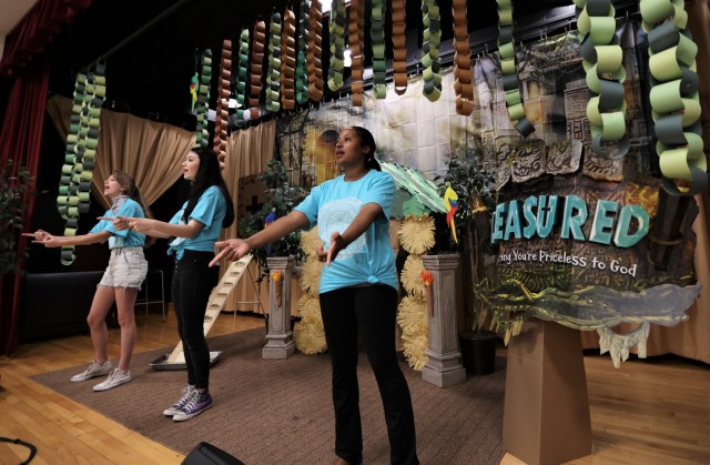 Dev Hawkins (right), along with two other volunteers, lead the children in song on the opening day of Vacation Bible School July 19, 2021.