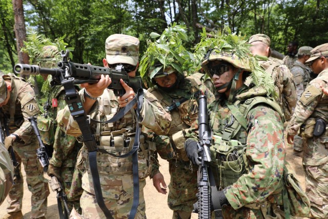 U.S. Army Spc. Vuongkhang Luong, an Adairsville, Georgia, native and infantryman with 1st Battalion, 28th Infantry Regiment "Black Lions," 3rd Infantry Division, looks down the sights of a Japan Ground Self-Defense Force weapon during exercise...